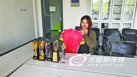 接受采访时展示国家队队服。